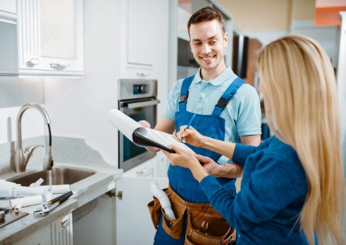 Appliance technician diagnosing a refrigerator during an in-home service call